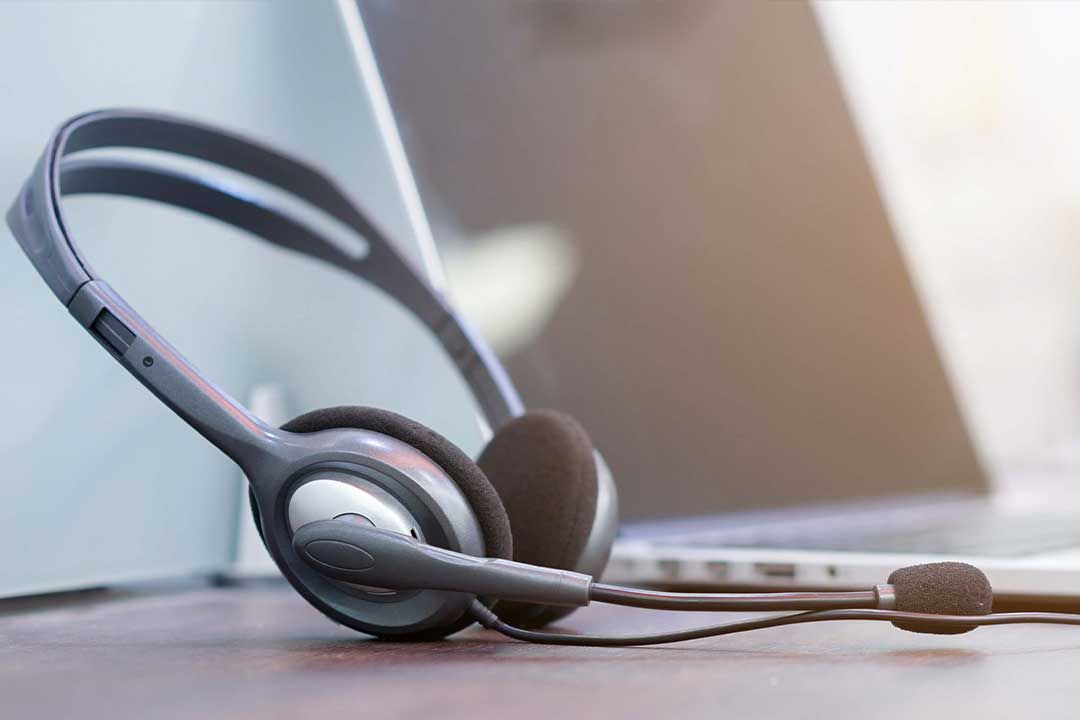 Headset sitting on a desk next to a laptop.